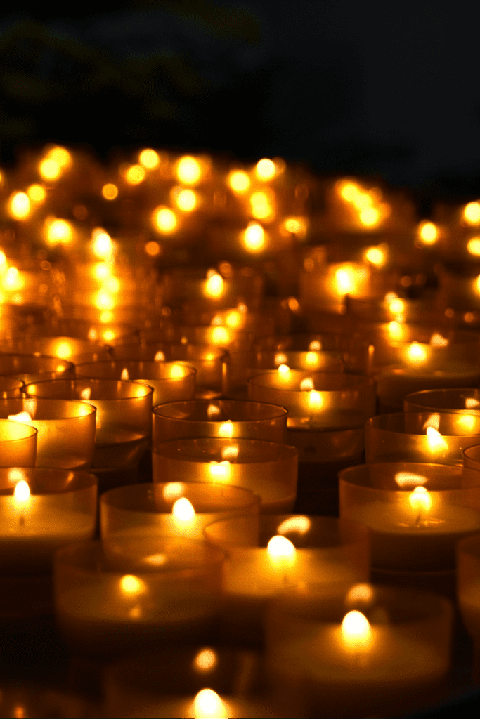 hundreds of candles in the dark, representing the light and spirits of the invisible world.